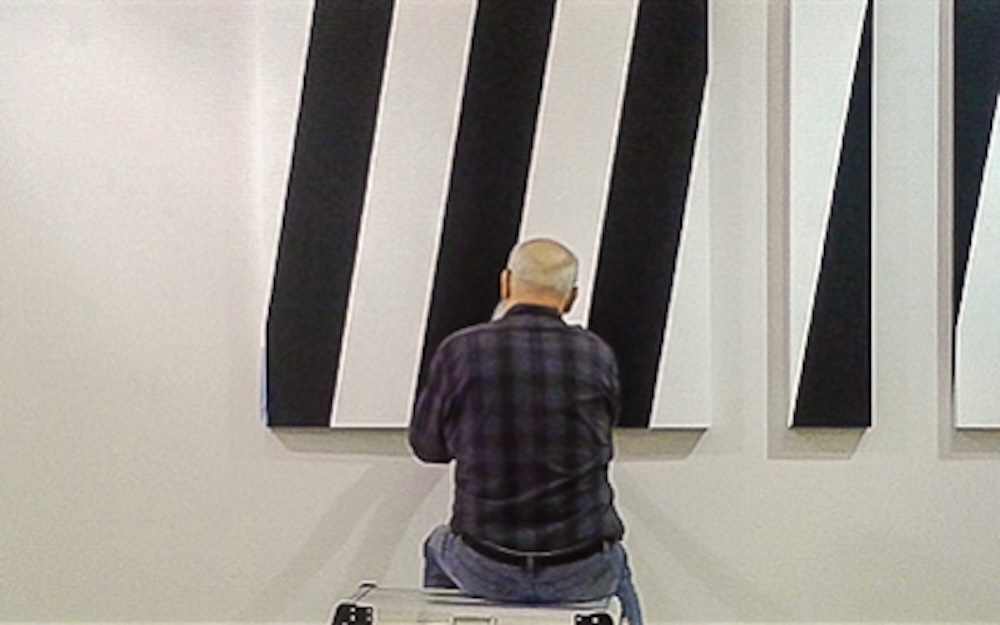 Konstnären Torsten Ridell framför sina konstverk. Foto: Konstlitografiska Museet.